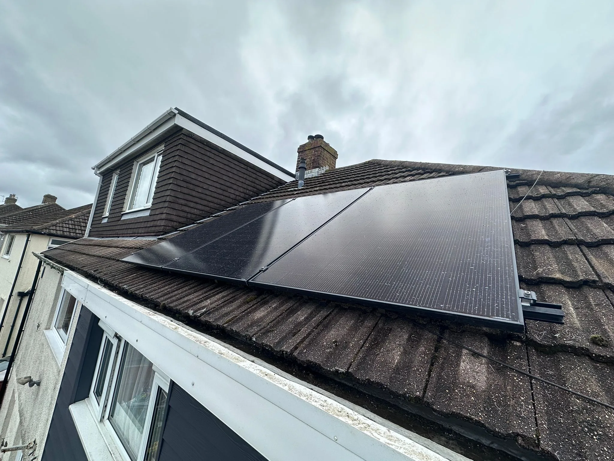 Residential roof with black solar panels installed
